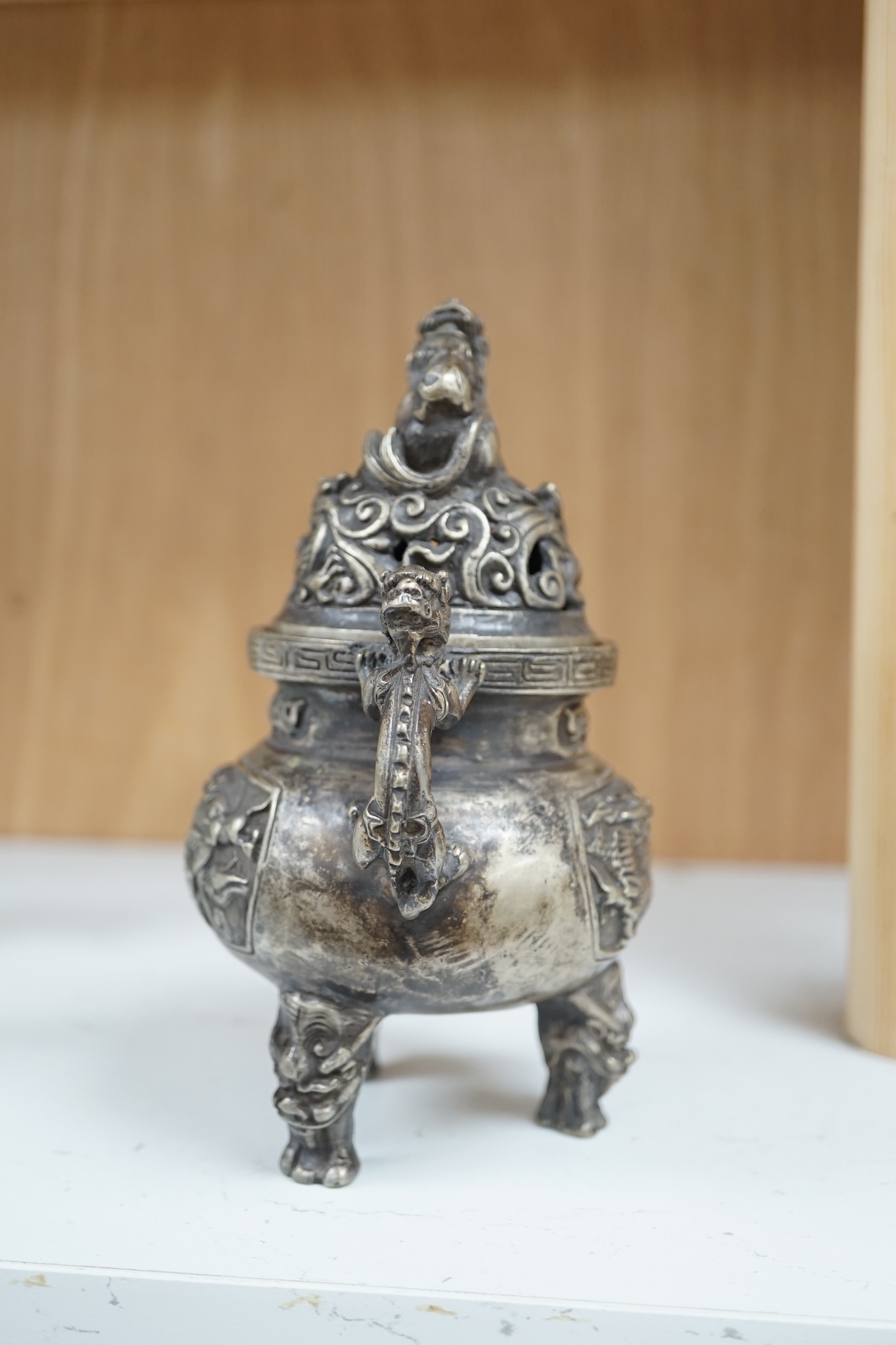 A Chinese silvered bronze lidded ‘dragon’ censer, 16cm tall. Condition - fair to good